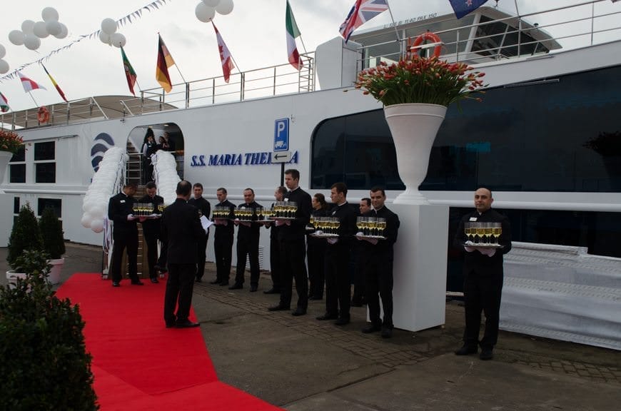 Waiters with champagne gather outside the S.S. Maria Theresa in Amsterdam as the hour of her christening approaches. Photo © 2015 Aaron Saunders