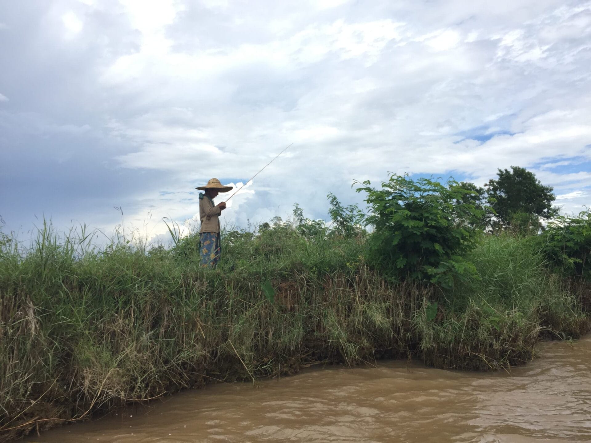 A man fishes for his lunch on the banks of Inle Lake. © 2015 Gail Jessen