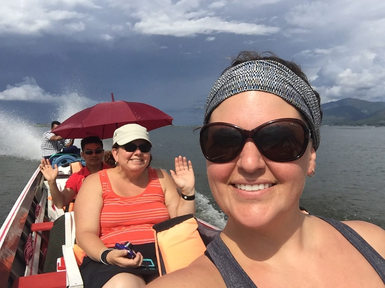 Me, Heather, Nanda, and our captain enjoy perfect weather on the bright blue lake, surrounded by mountain peaks on every side. © 2015 Gail Jessen