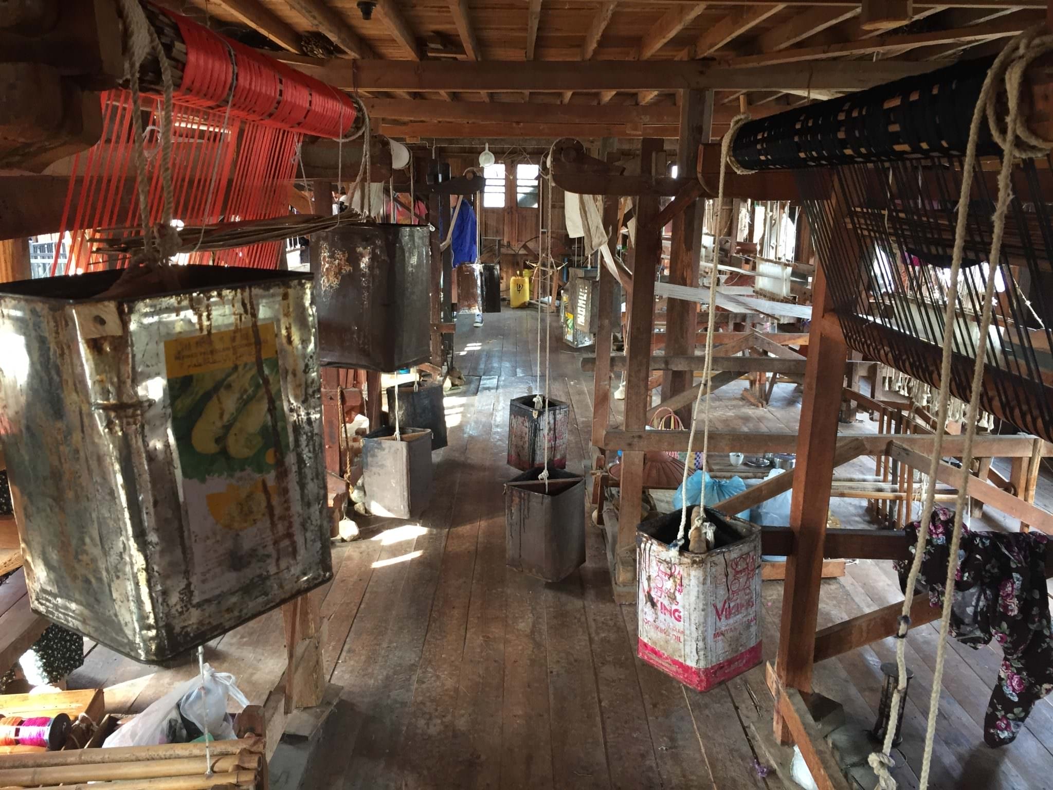 Old tin cans full of rocks act as a counter weight on the creaky wooden looms. The air was hot, sticky, and smelled like flowers. © 2015 Gail Jessen