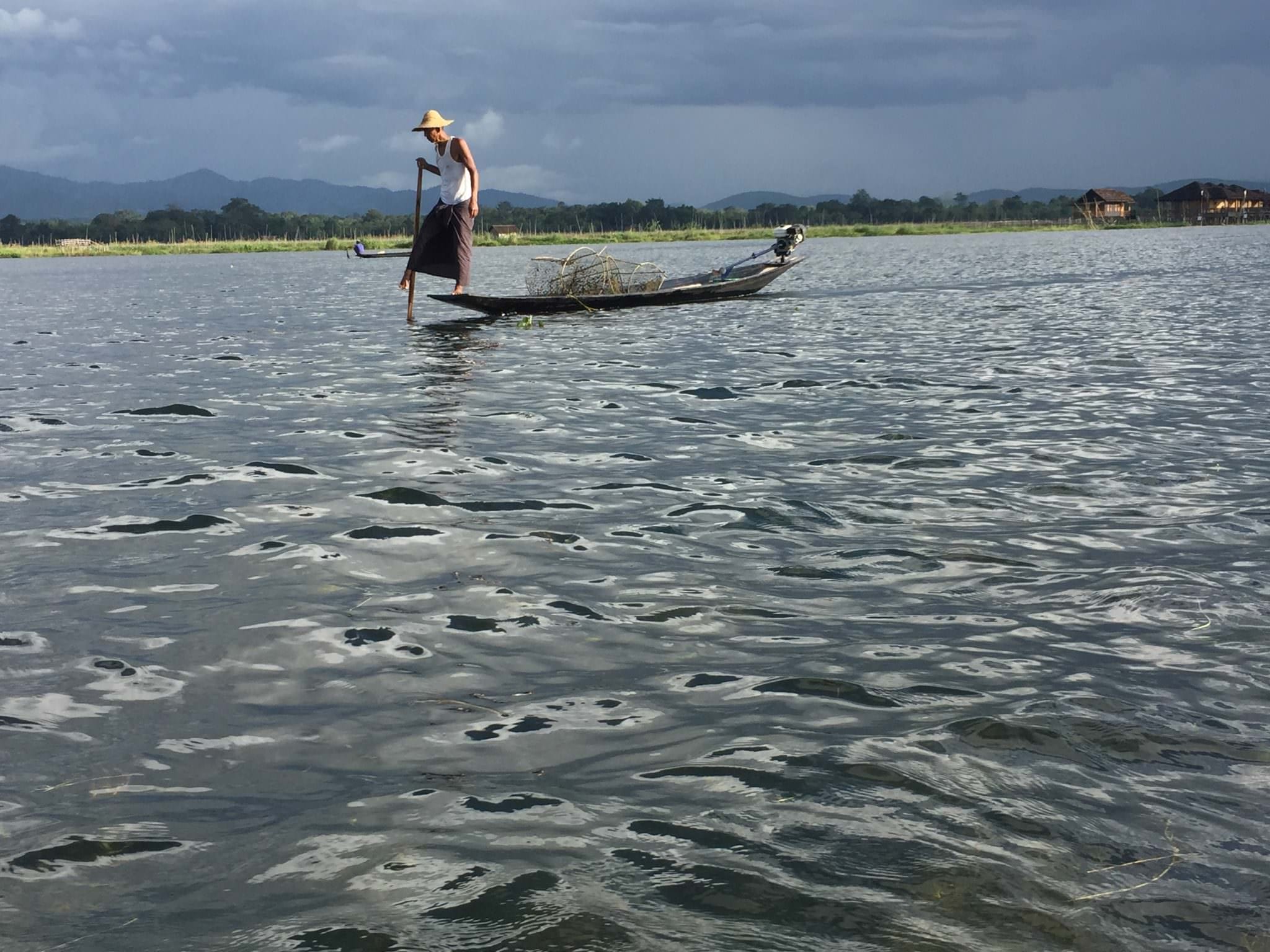 Wearing a traditional longhi around his waist, this fisherman paddles with his boat with his right foot. © 2015 Gail Jessen