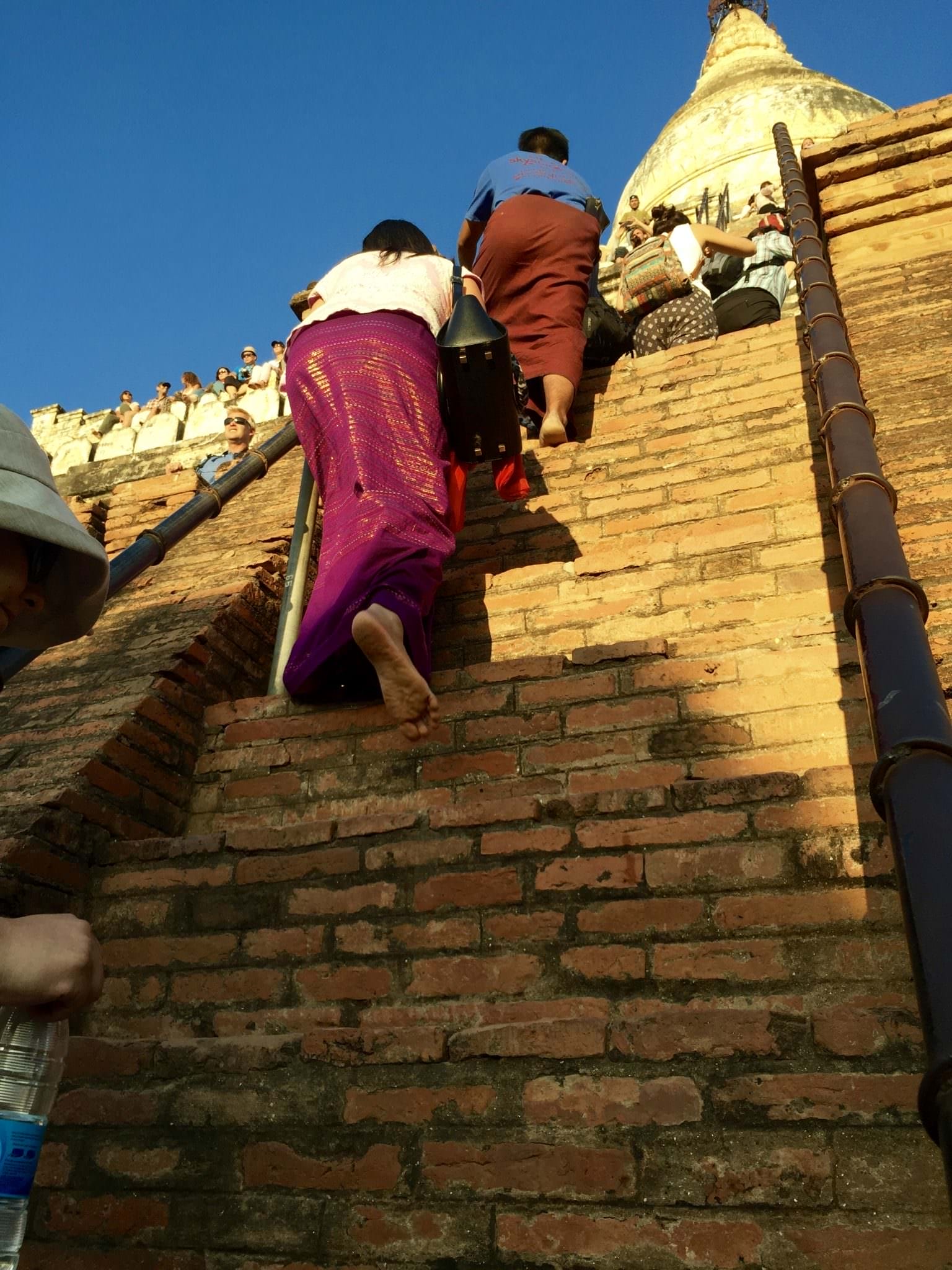 I can't imagine doing this climb in a longhi. I was in capri yoga pants and I barely made it without a face plant or two. Oh, and like everything in Myanmar, you must be barefoot. © 2015 Gail Jessen