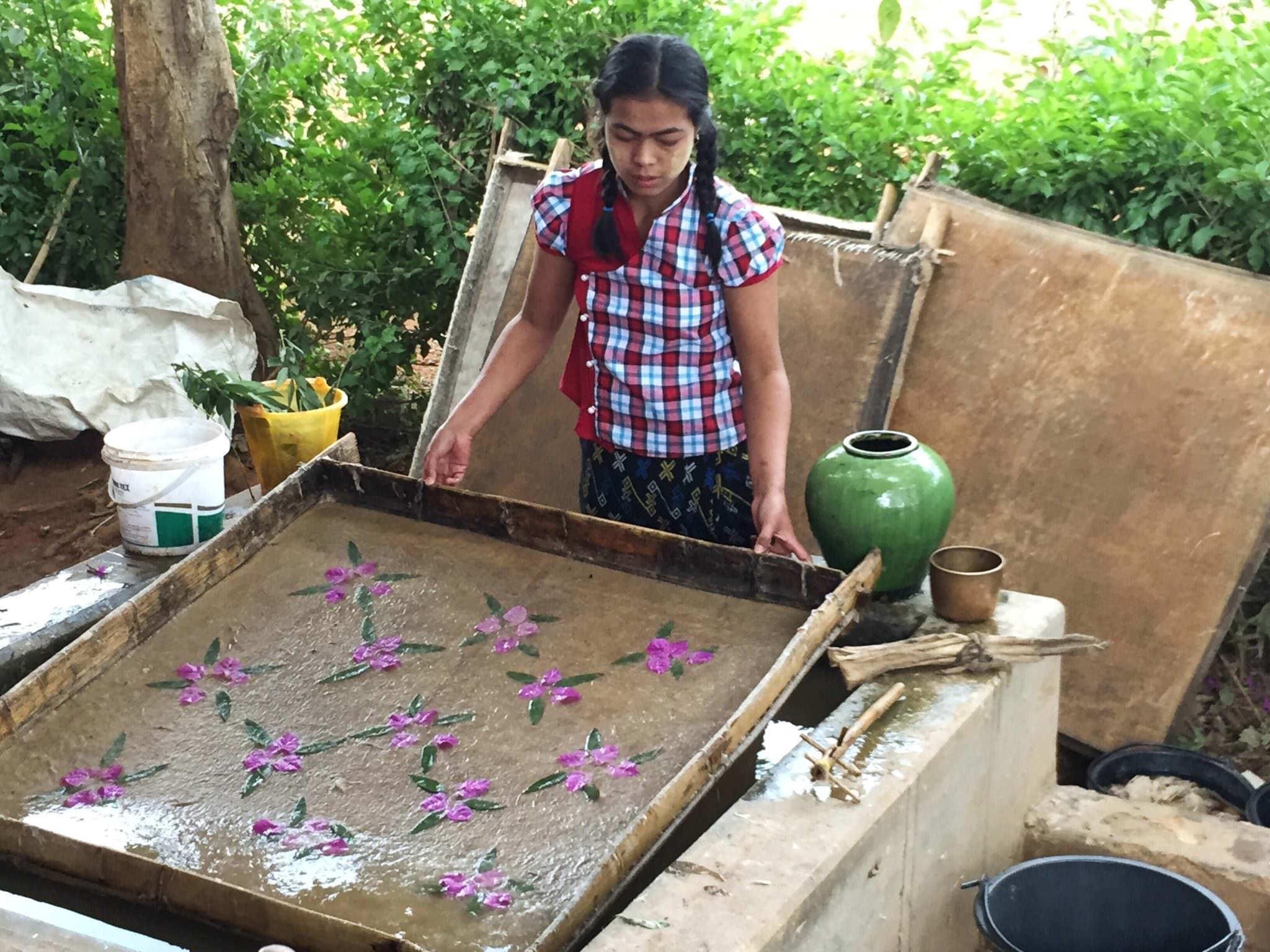 After placing flower petals in the frame that holds the bamboo paper paste, she carefully drains the water through the bamboo. (c) 2015 Gail Jessen