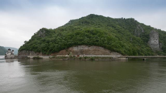 Rock sculpture of King Decebalus and an Orthodox church at the Iron Gates. © 2016 Ralph Grizzle